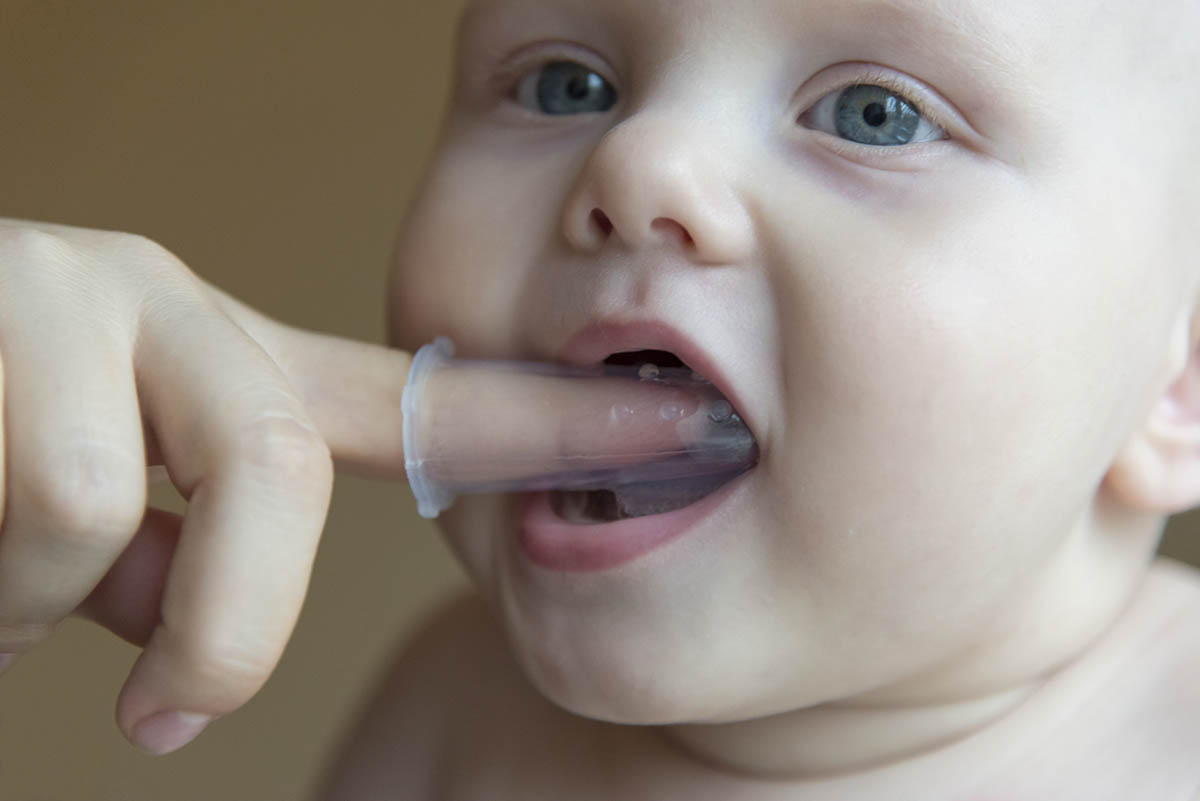 parent brushing teeth of child after asking how do I clean my babys teeth