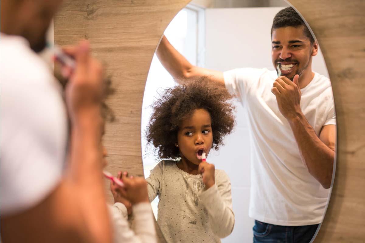 Family brushing teeth to prevent plaque buildup