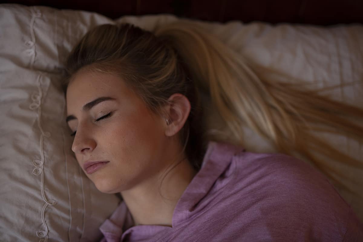 woman sleeping and struggling with teeth grinding