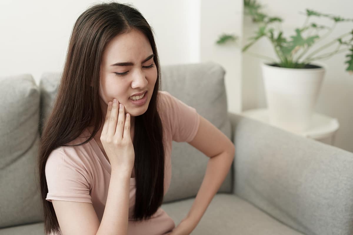 young woman in pain from tooth cavity