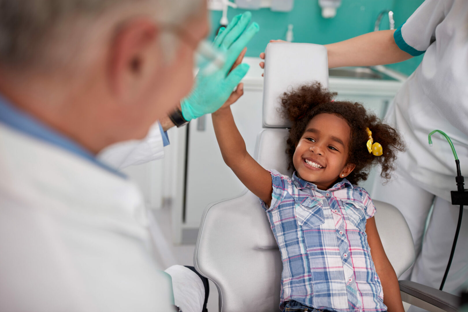 lovely kid with dentist after repairing teeth