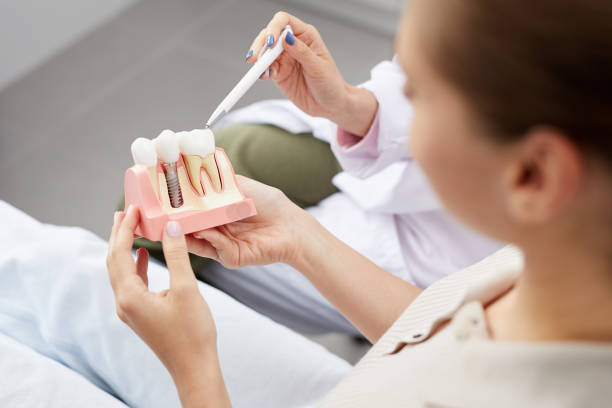 a dental professional educating his patient about dental implants