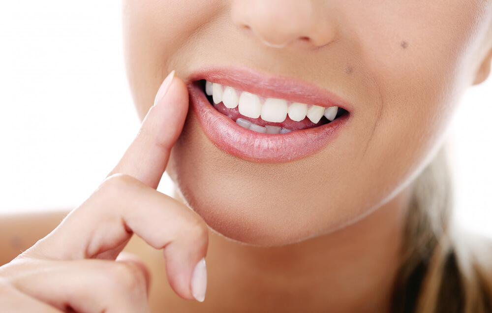 woman pointing to her nice set of teeth