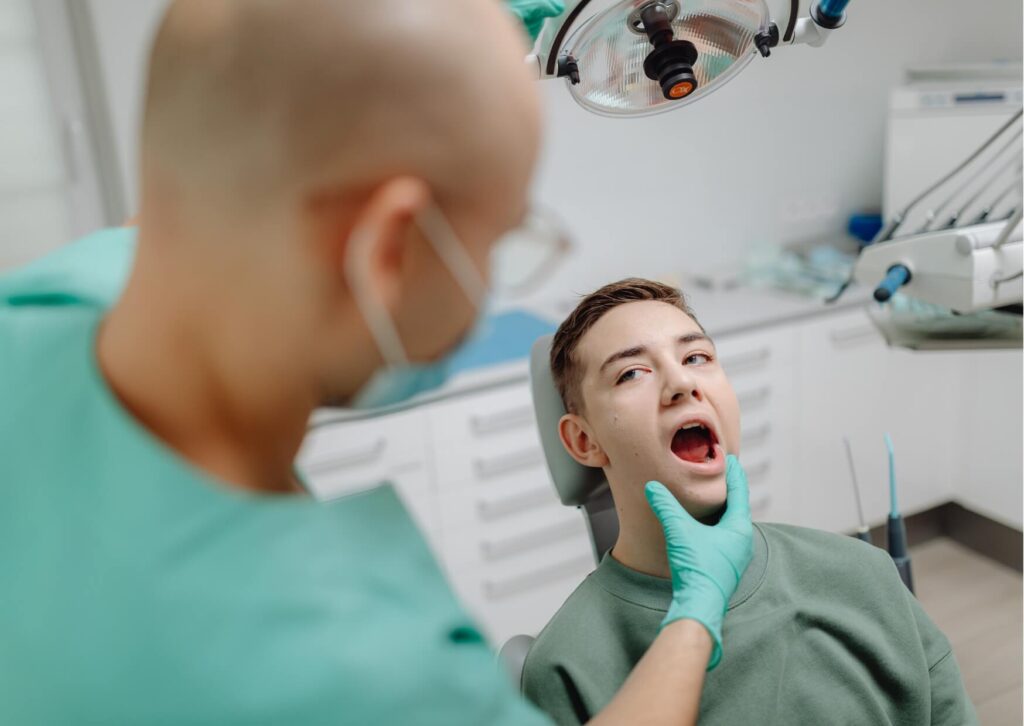 Dentist examining a patient's mouth during a wisdom tooth evaluation to monitor eruption progress and determine how long a wisdom tooth may take to come in.