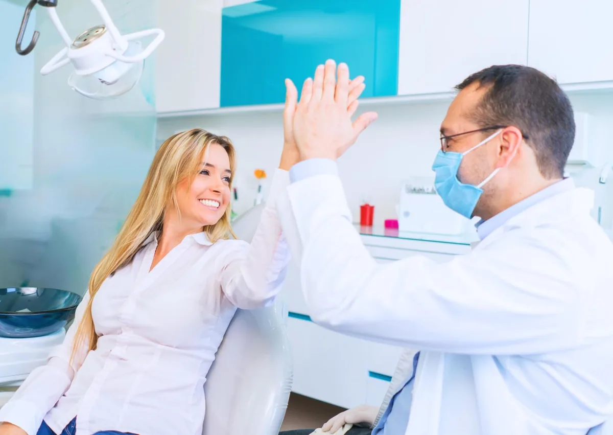 Dentist and patient celebrating a successful dental visit focused on cavity prevention and oral health.