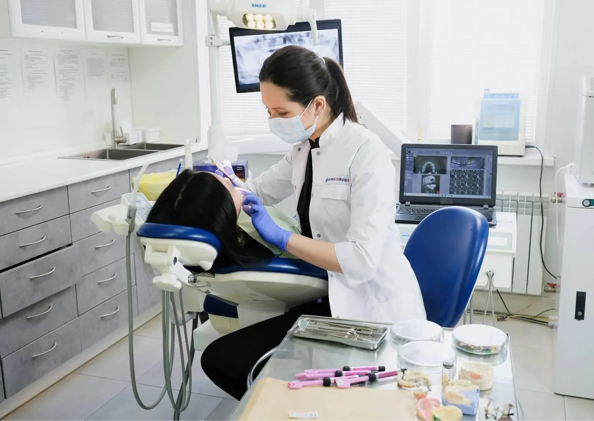 Dentist performing an oral examination to determine whether root canal treatment or tooth extraction is appropriate.