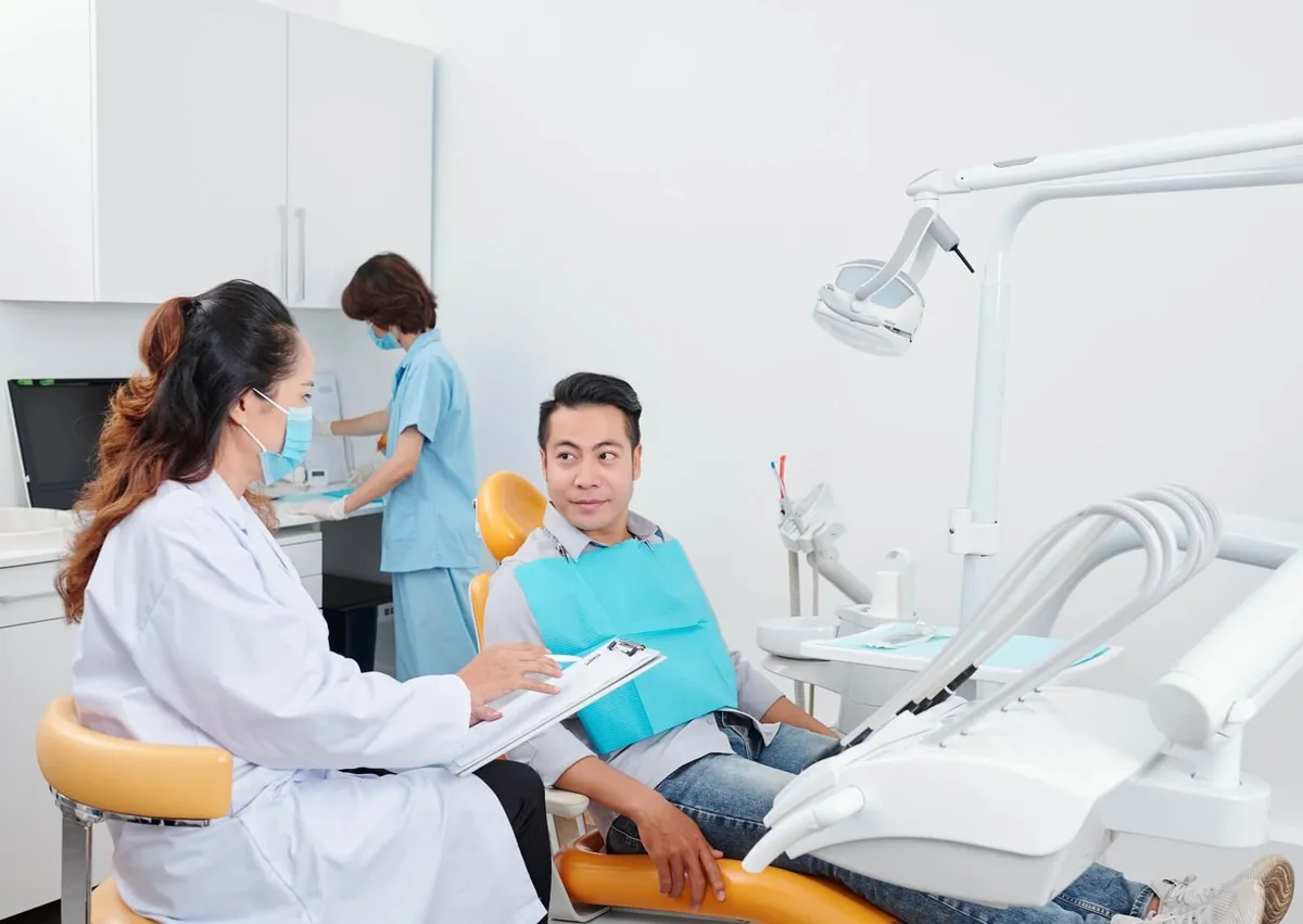 Dentist advising a patient on how long after fluoride treatment they can eat.