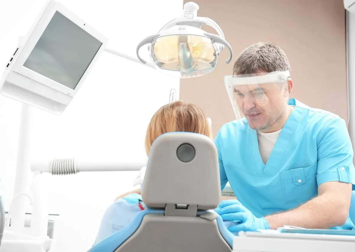 Dentist discussing with a patient during a consultation about total root canal and crown cost without insurance.